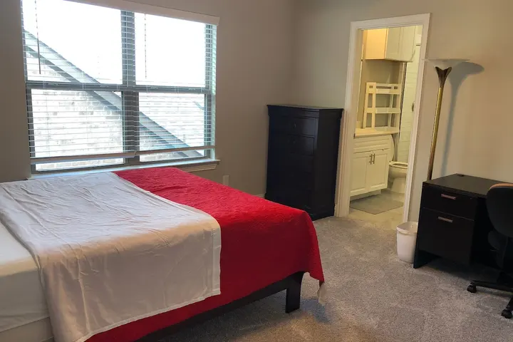 Queen bed with private bath beyond