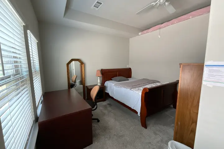 Bed with a sleigh frame and a desk under the window