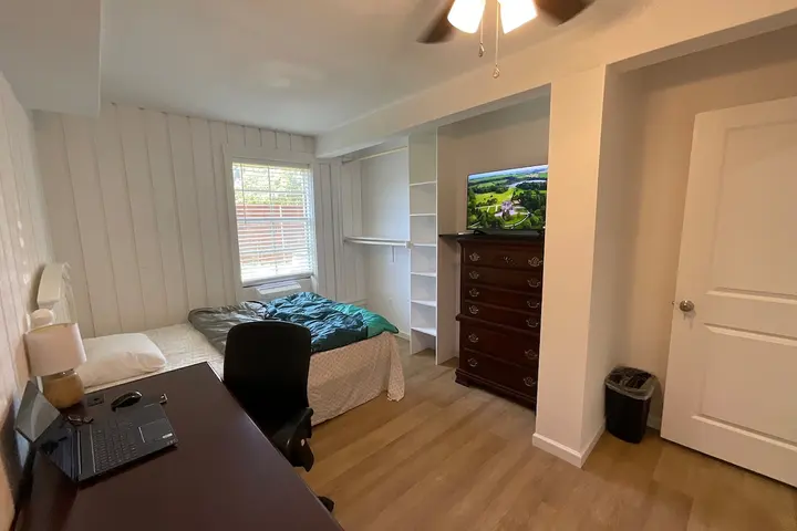 Furnished bedroom with hardwood floors