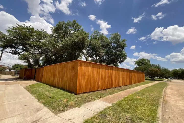 Large fenced backyard shaded by mature trees