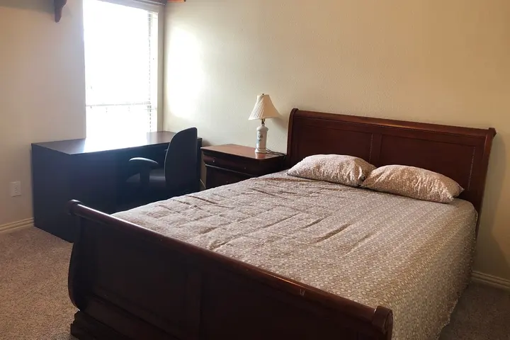 Queen bed with desk beyond