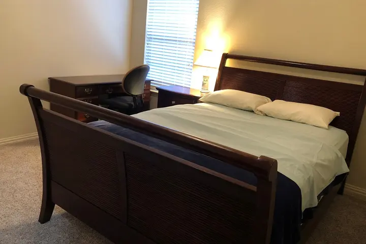 Queen bed with warm lamplight